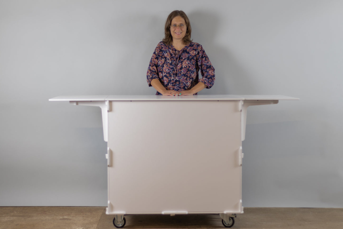 A person standing behind the mobile coffee cart, demonstrating its convenient height and work area