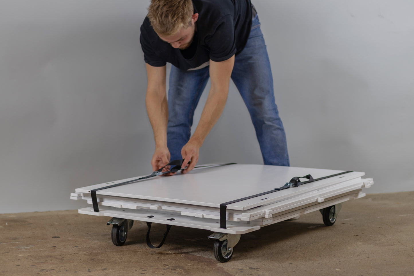 Straps being attached to secure the mobile coffee cart flatpack for easy transport.